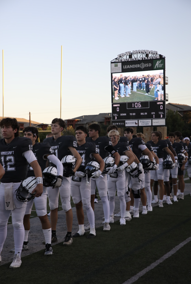 Varsity football players line up before the start of a game at Monroe Stadium. 